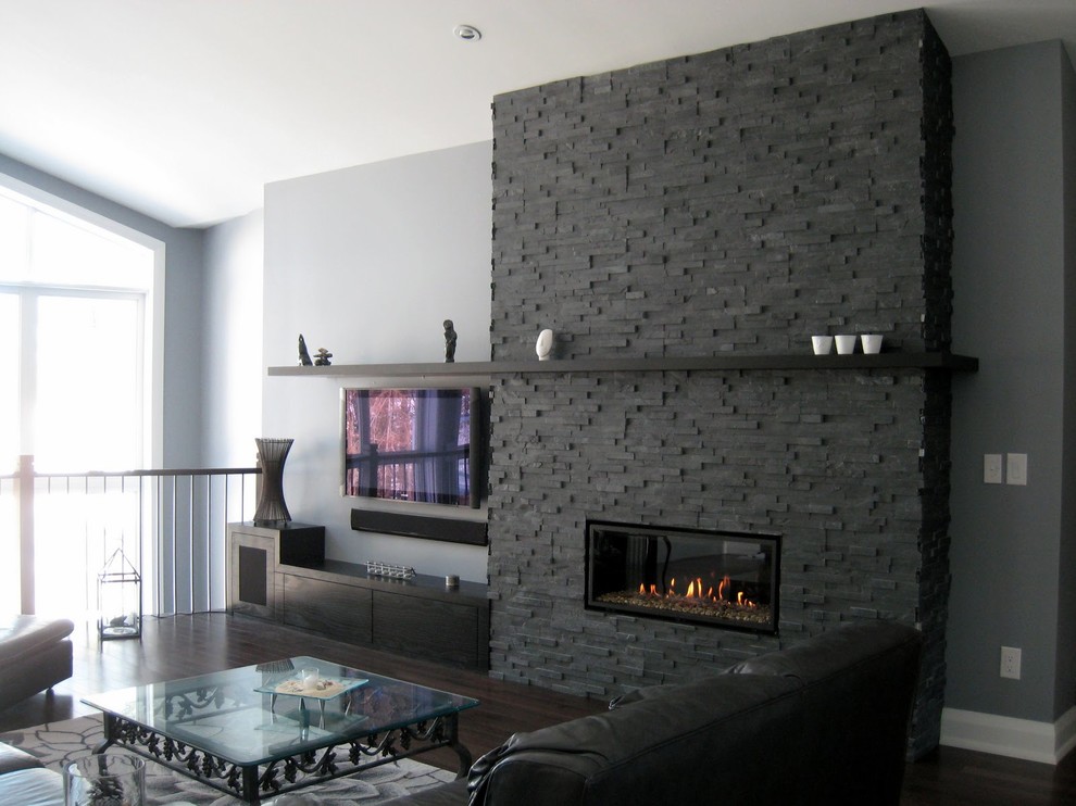 Idee per un soggiorno classico con pareti grigie, parquet scuro, camino lineare Ribbon, cornice del camino in pietra e parete attrezzata