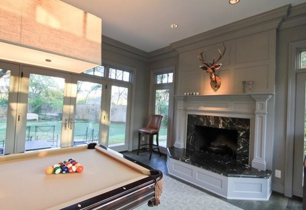 Classic enclosed games room in Los Angeles with a game room, grey walls, dark hardwood flooring, a standard fireplace, a wooden fireplace surround and a built-in media unit.