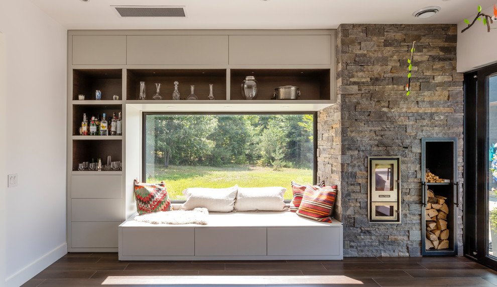 Modernes Wohnzimmer mit weißer Wandfarbe, dunklem Holzboden, Kaminumrandung aus Stein und braunem Boden in Toronto
