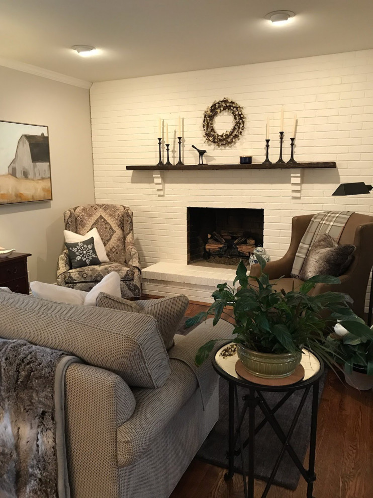 Inspiration pour une petite salle de séjour rustique ouverte avec un mur blanc, un sol en bois brun, une cheminée standard, un manteau de cheminée en brique, un téléviseur indépendant et un sol marron.