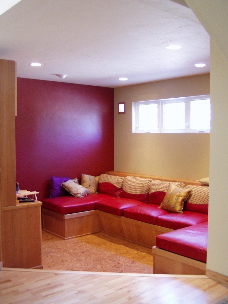 На фото: открытая гостиная комната в стиле фьюжн с красными стенами, пробковым полом, скрытым телевизором и коричневым полом с