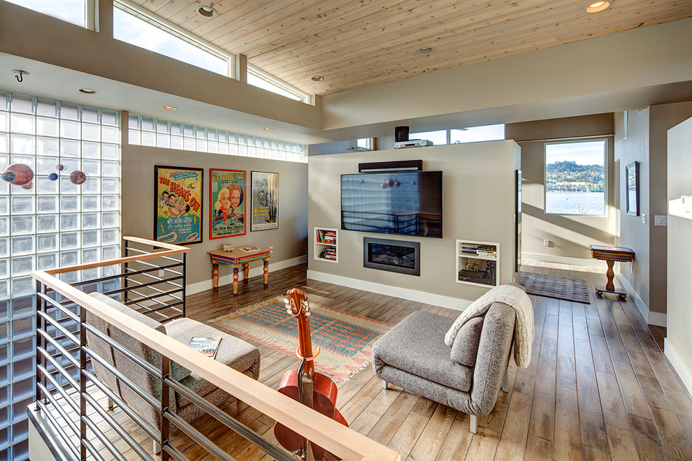 На фото: двухуровневая гостиная комната среднего размера в современном стиле с бежевыми стенами, паркетным полом среднего тона, горизонтальным камином, фасадом камина из металла и телевизором на стене