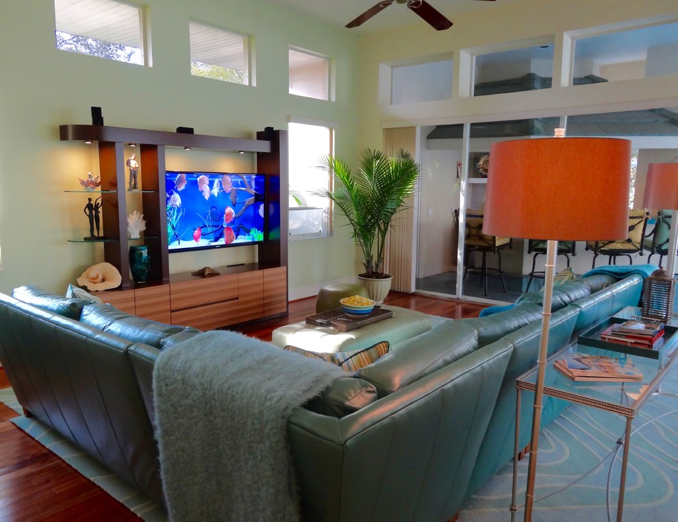 Inspiration for a large transitional open concept medium tone wood floor family room remodel in Orange County with green walls and a wall-mounted tv