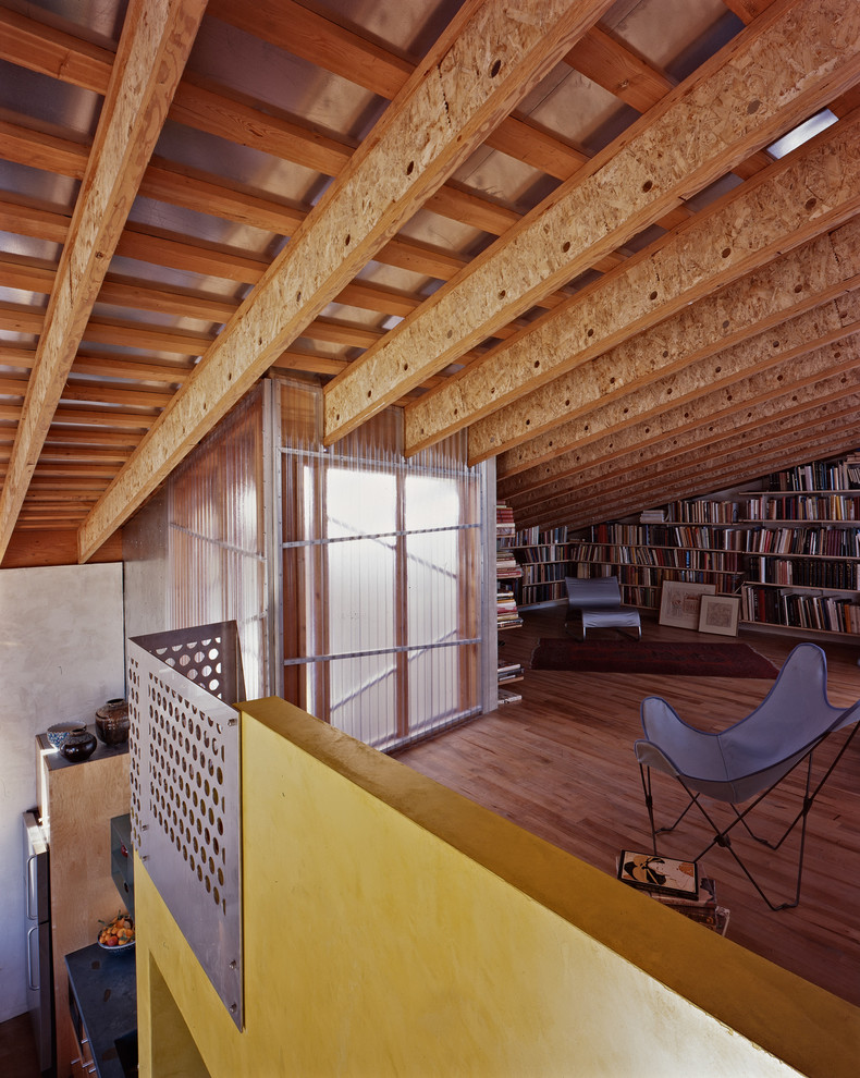 Стильный дизайн: гостиная комната в стиле лофт с с книжными шкафами и полками и желтыми стенами - последний тренд