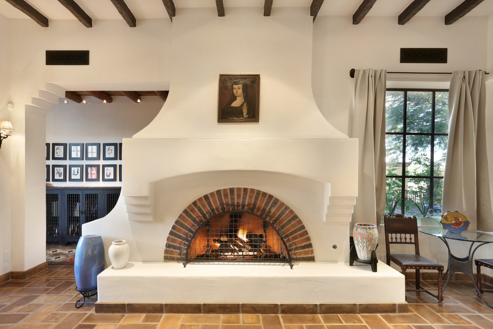 フェニックスにあるラグジュアリーな広いサンタフェスタイルのおしゃれなファミリールーム (白い壁、標準型暖炉、レンガの暖炉まわり) の写真
