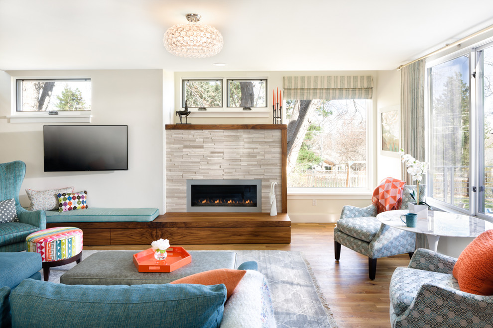 Großes, Offenes Modernes Wohnzimmer mit weißer Wandfarbe, hellem Holzboden, Kamin, Kaminumrandung aus Stein und TV-Wand in Denver