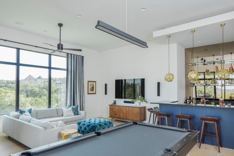Пример оригинального дизайна: гостиная комната в современном стиле с домашним баром, белыми стенами, телевизором на стене и бежевым полом