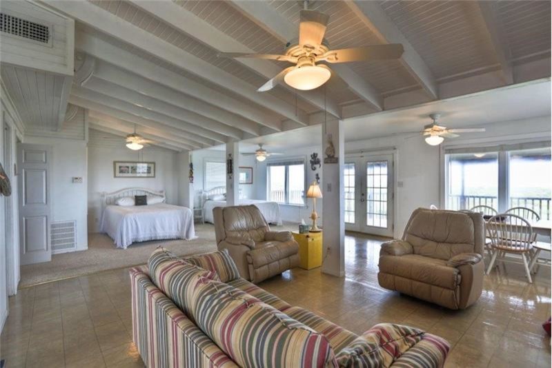 Kleines Maritimes Wohnzimmer mit weißer Wandfarbe, Keramikboden und beigem Boden in Houston
