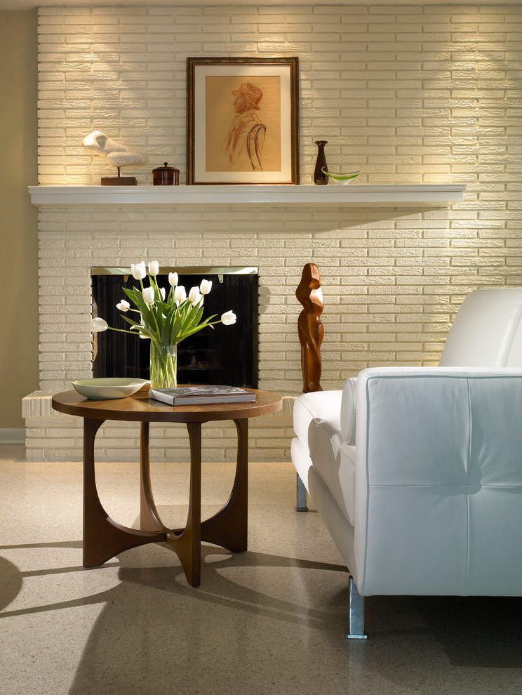 На фото: изолированная гостиная комната среднего размера в стиле модернизм с бежевыми стенами, полом из линолеума, стандартным камином и фасадом камина из кирпича с