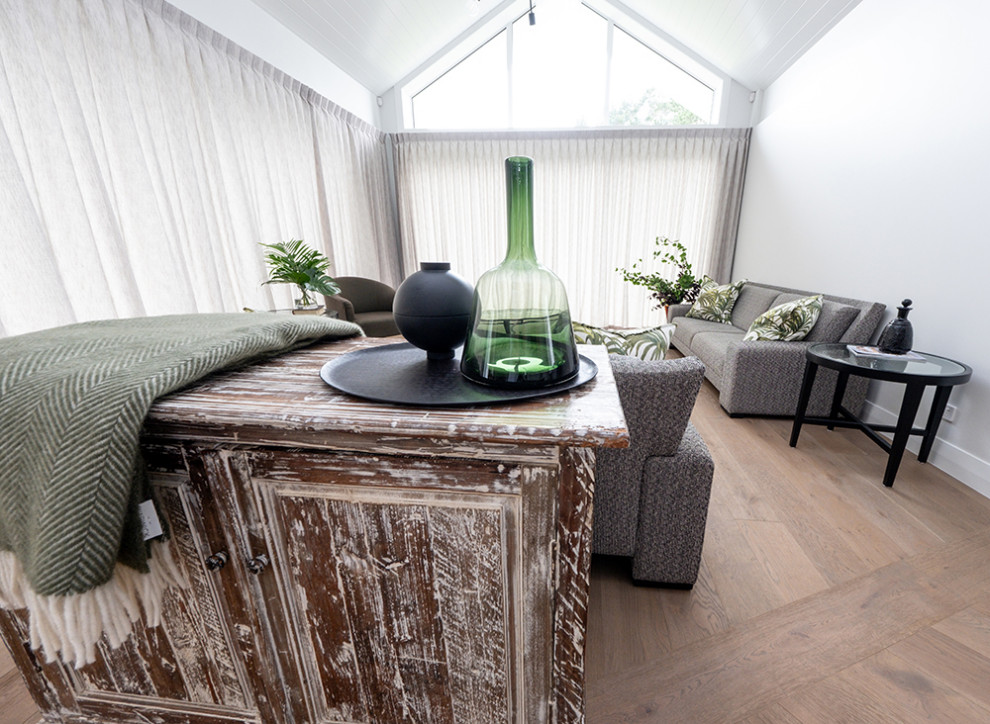 Offenes Modernes Wohnzimmer mit grauer Wandfarbe, braunem Holzboden und braunem Boden in Auckland