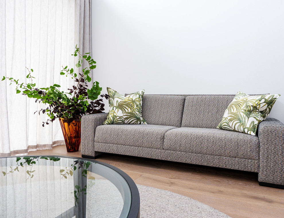 Offenes Modernes Wohnzimmer mit grauer Wandfarbe, braunem Holzboden und braunem Boden in Auckland