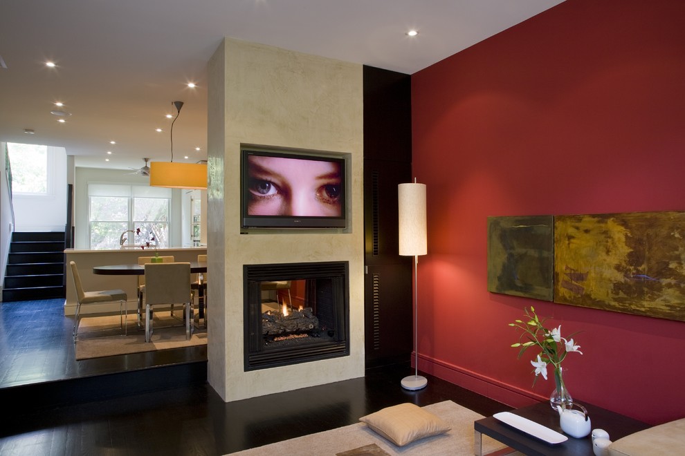 Idéer för ett modernt allrum med öppen planlösning, med röda väggar, en dubbelsidig öppen spis och en väggmonterad TV