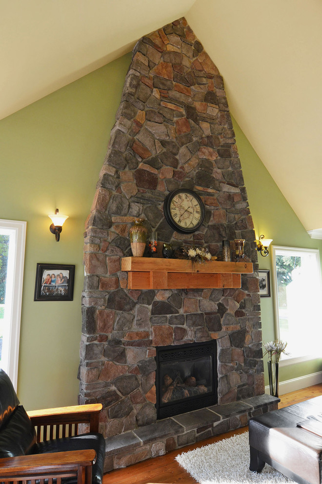Example of a mid-sized arts and crafts enclosed dark wood floor family room design in Vancouver with green walls, a standard fireplace and a stone fireplace