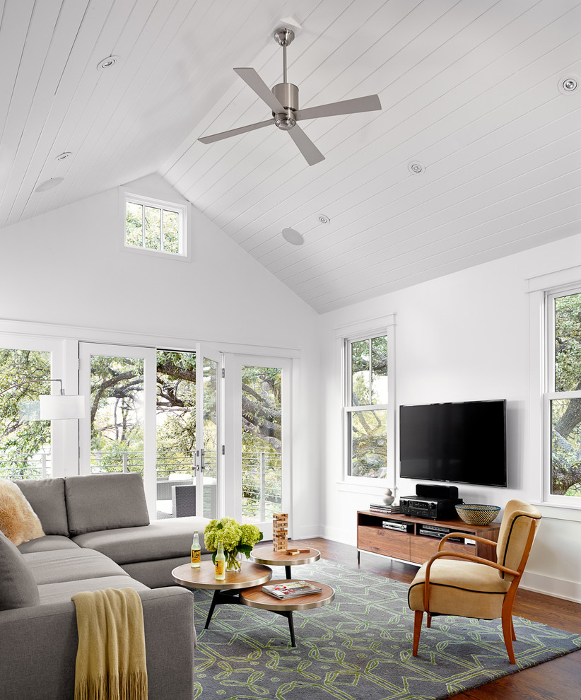 Landhausstil Wohnzimmer ohne Kamin mit weißer Wandfarbe, dunklem Holzboden und TV-Wand in Austin