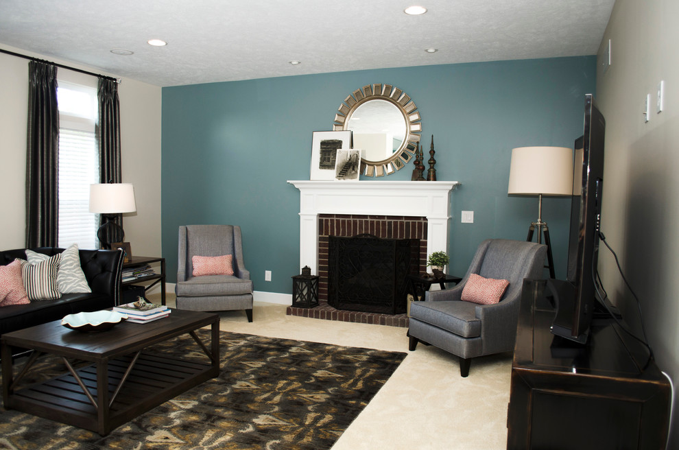 Mittelgroßes, Offenes Klassisches Wohnzimmer mit blauer Wandfarbe, Teppichboden, Kaminumrandung aus Holz und freistehendem TV in Sonstige