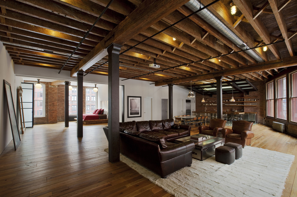 Ejemplo de sala de estar abierta urbana grande con paredes multicolor, suelo de madera clara, suelo marrón y alfombra