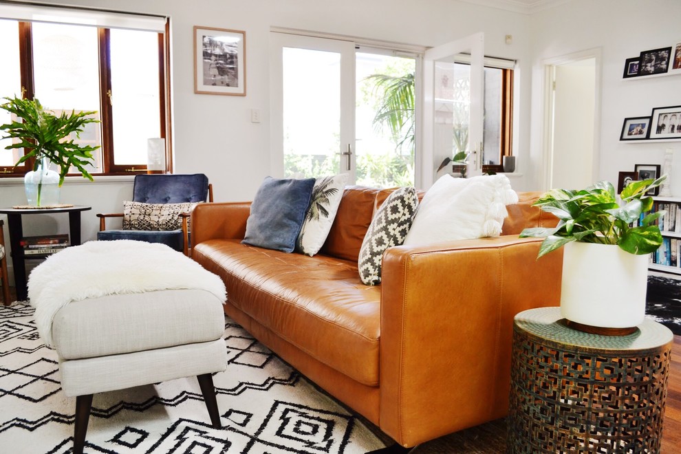 Immagine di un soggiorno eclettico di medie dimensioni e aperto con pareti bianche, parquet scuro e TV autoportante