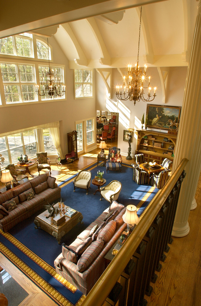 Esempio di un ampio soggiorno chic aperto con libreria, pareti beige, pavimento in legno massello medio e pavimento marrone