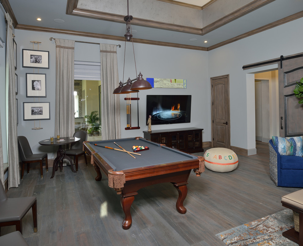 Foto de sala de juegos en casa cerrada bohemia grande con paredes grises, suelo de madera oscura, televisor colgado en la pared y suelo gris
