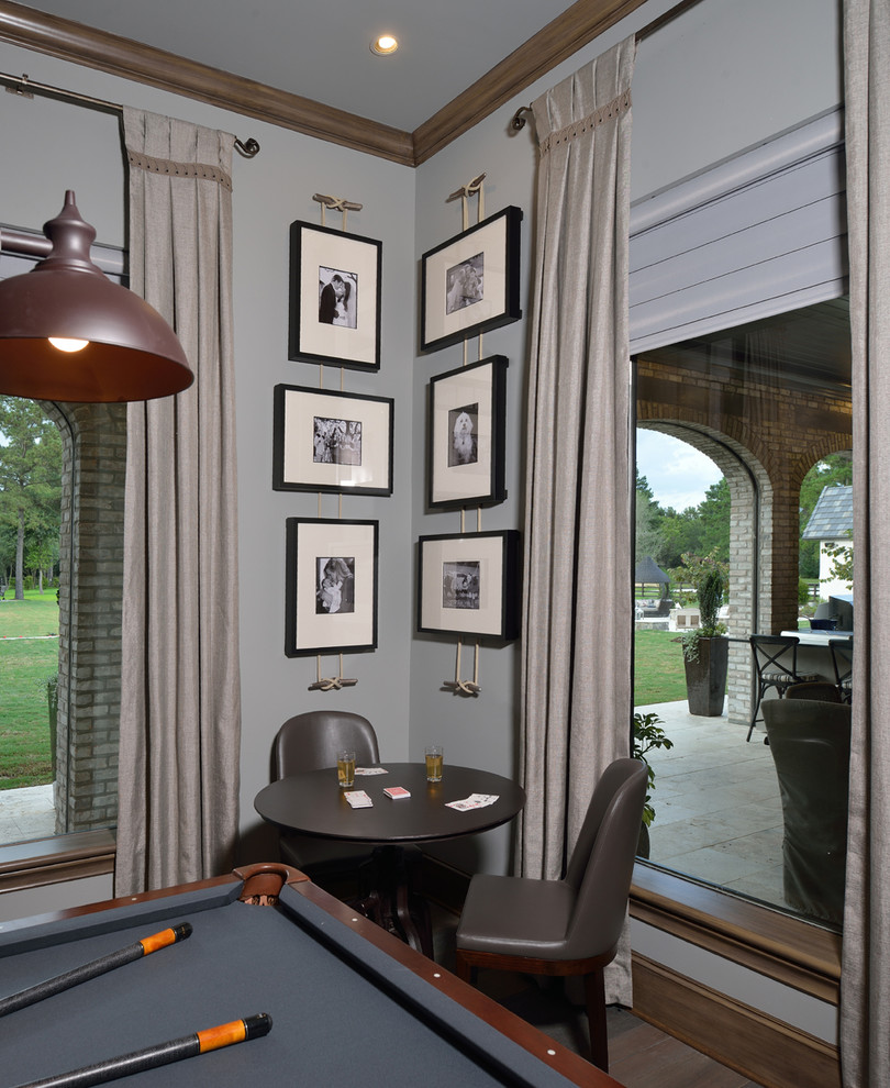 This is an example of a large eclectic enclosed games room in Houston with a game room, grey walls, dark hardwood flooring, a wall mounted tv and grey floors.