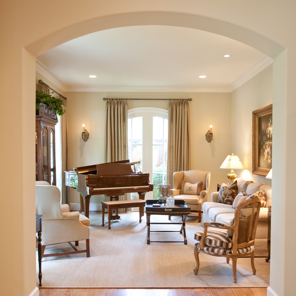 Example of a french country medium tone wood floor family room design in Houston with a music area, beige walls and no tv