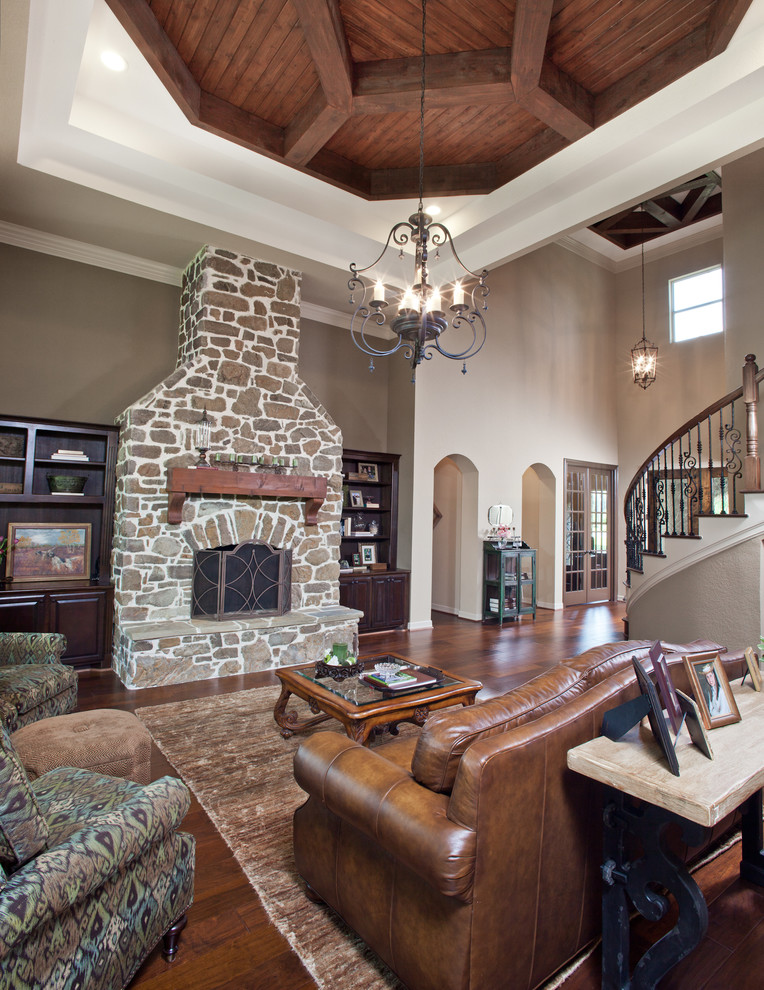 This is an example of a medium sized traditional open plan games room in Houston with beige walls, medium hardwood flooring, a standard fireplace and a stone fireplace surround.