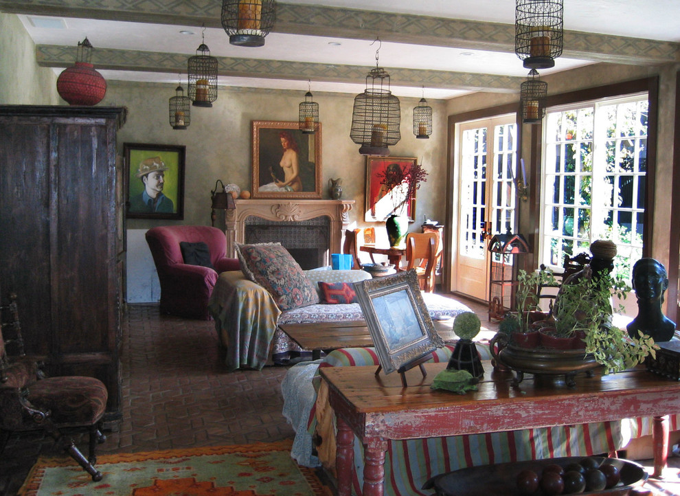 Modelo de sala de estar abierta bohemia grande con suelo de baldosas de terracota, todas las chimeneas, marco de chimenea de piedra y televisor retractable