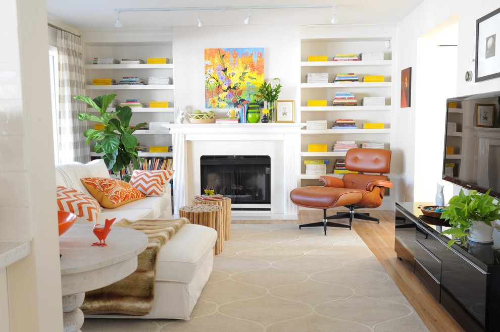 Immagine di un soggiorno classico di medie dimensioni e chiuso con pareti bianche, pavimento in laminato, camino classico e TV a parete