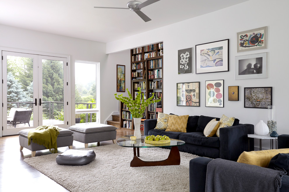 Foto de sala de estar con biblioteca abierta contemporánea con paredes blancas y suelo de madera oscura