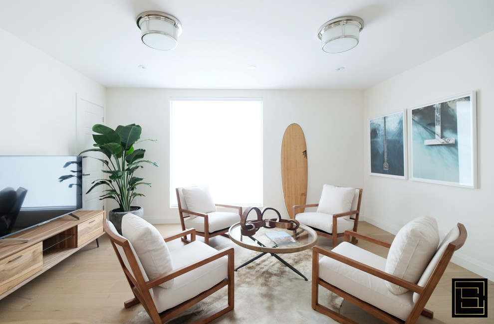 Immagine di un soggiorno minimalista con pareti bianche, parquet chiaro e TV autoportante