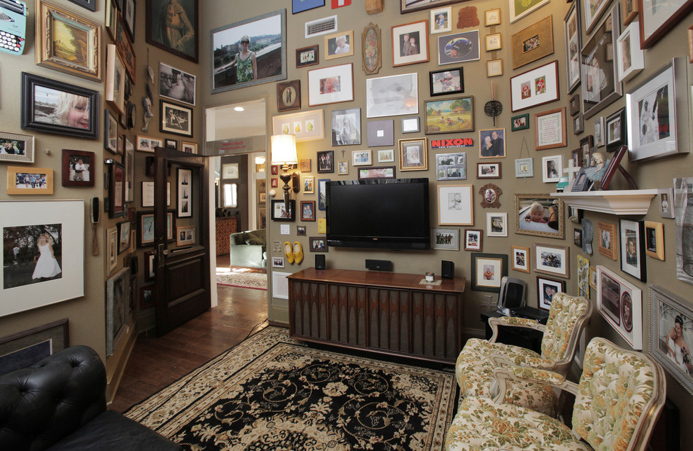 Modelo de sala de estar cerrada clásica renovada con paredes beige, suelo de madera oscura y televisor colgado en la pared