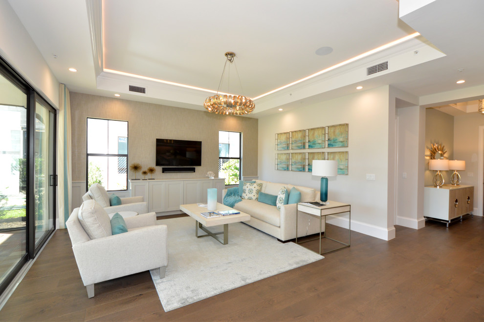 Esempio di un soggiorno stile marino con pareti beige, pavimento in legno massello medio, TV a parete, pavimento marrone e tappeto