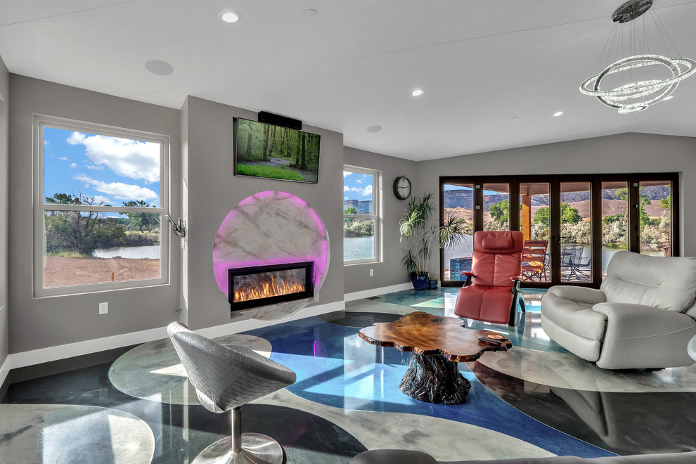 Photo of a medium sized contemporary open plan games room in Denver with grey walls, concrete flooring, a metal fireplace surround, a wall mounted tv and multi-coloured floors.