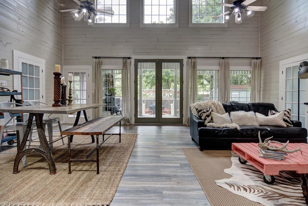 This is an example of a medium sized rural open plan games room in Austin with grey walls, medium hardwood flooring, no fireplace, a freestanding tv and grey floors.