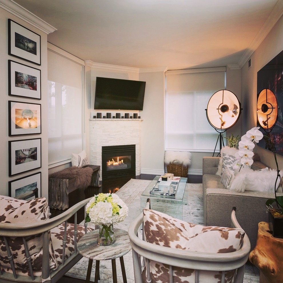 Mittelgroßes, Abgetrenntes Modernes Wohnzimmer mit weißer Wandfarbe, dunklem Holzboden, Eckkamin, Kaminumrandung aus Stein, TV-Wand und braunem Boden in Toronto