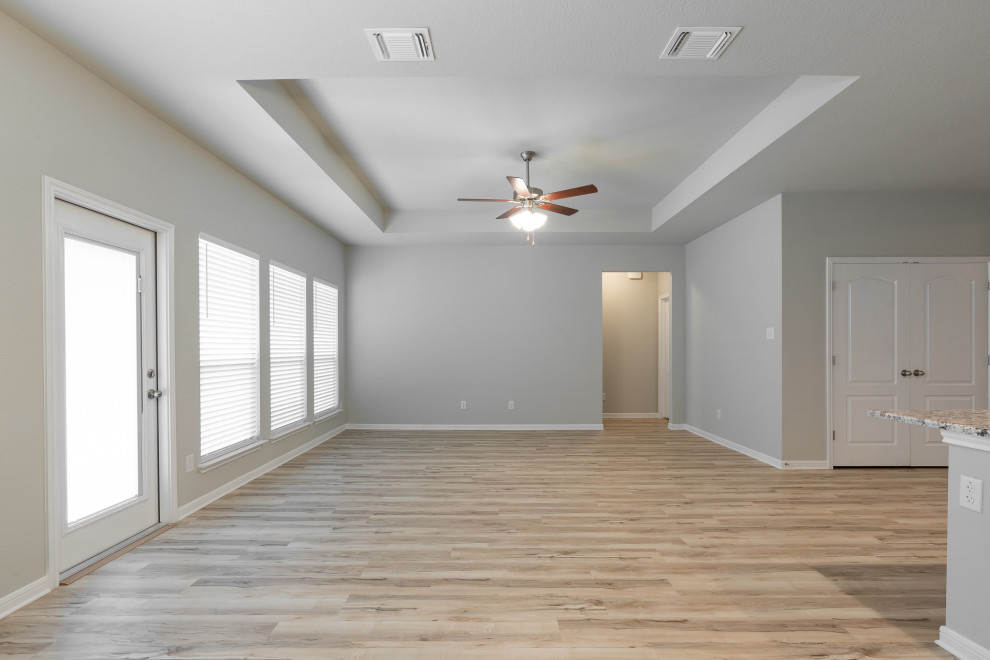 Réalisation d'une salle de séjour craftsman ouverte avec un mur gris, un sol en vinyl, un sol beige et un plafond décaissé.
