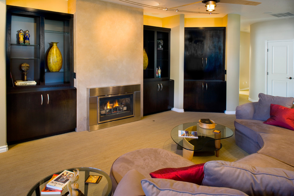 Imagen de sala de estar abierta contemporánea de tamaño medio con moqueta, todas las chimeneas, marco de chimenea de metal, televisor retractable y paredes amarillas