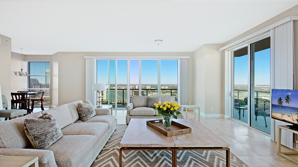 Foto de sala de estar abierta tradicional renovada de tamaño medio con paredes beige, suelo de mármol y televisor independiente