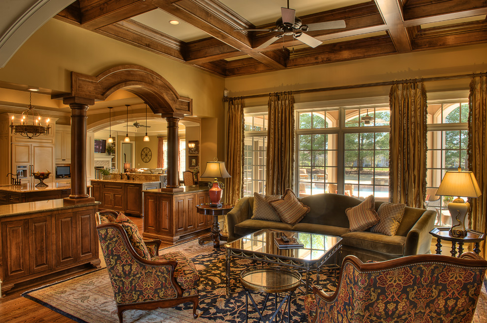 Fernseherloses, Offenes, Mittelgroßes Klassisches Wohnzimmer mit beiger Wandfarbe und braunem Holzboden in Sonstige
