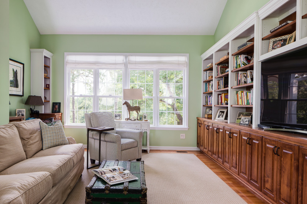 Mid-sized transitional enclosed light wood floor family room library photo in Atlanta with green walls, no fireplace and a media wall