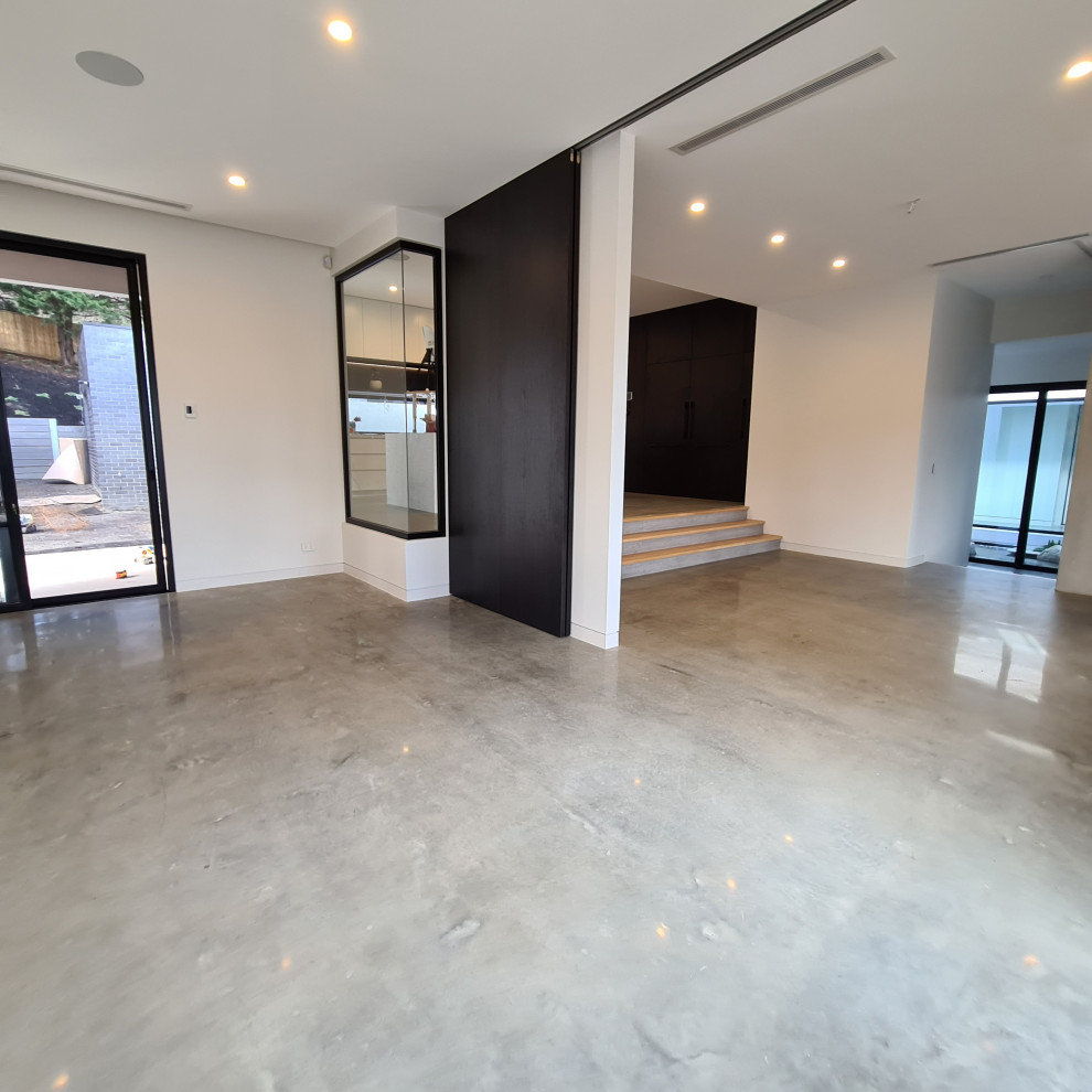 Medium sized contemporary enclosed games room in Melbourne with white walls, concrete flooring and grey floors.