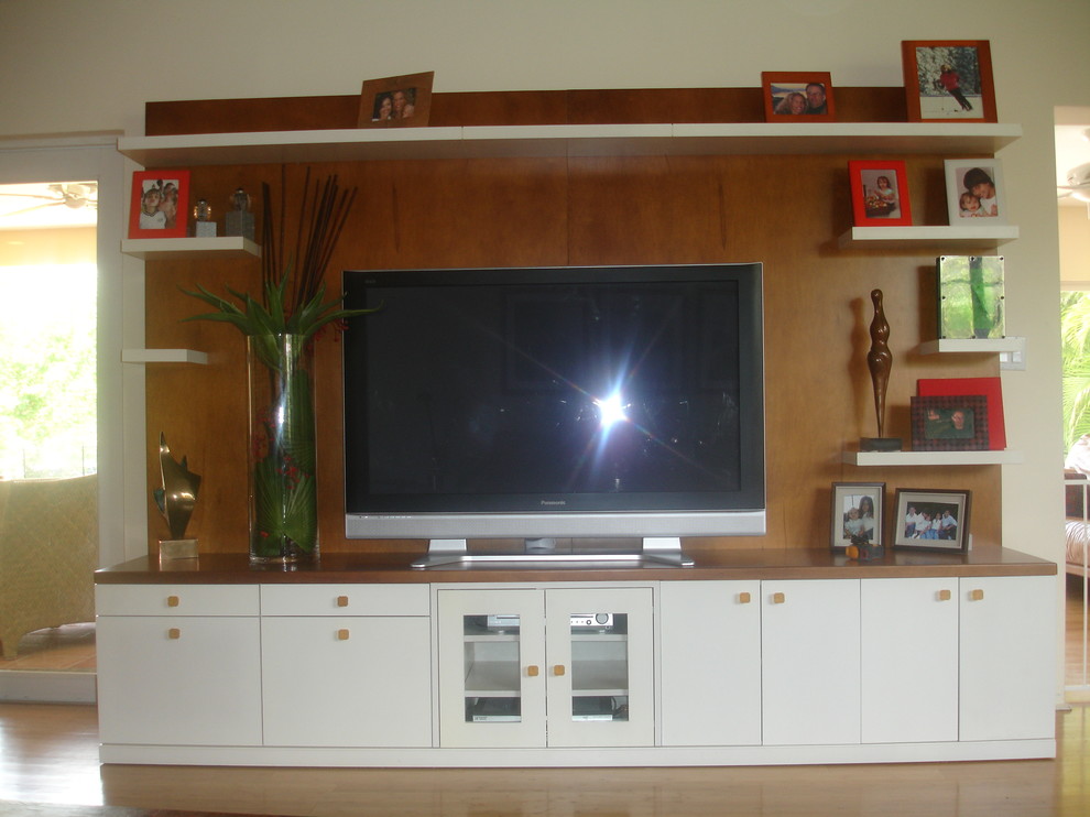 Modelo de sala de estar abierta contemporánea de tamaño medio sin chimenea con paredes beige, suelo de madera clara y televisor independiente