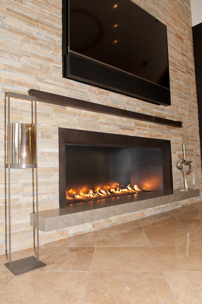 フェニックスにある中くらいなトランジショナルスタイルのおしゃれなオープンリビング (白い壁、トラバーチンの床、横長型暖炉、石材の暖炉まわり、壁掛け型テレビ) の写真