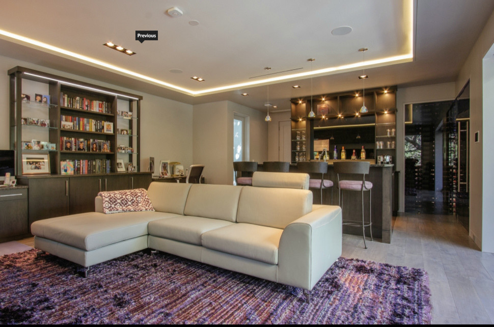 Immagine di un grande soggiorno minimal aperto con angolo bar, pareti beige, parquet chiaro, pavimento beige e TV a parete
