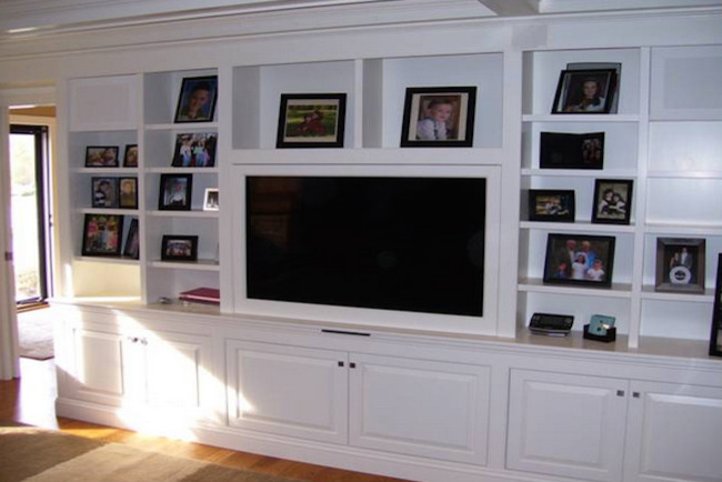 Inspiration for a transitional medium tone wood floor family room remodel in Providence with a media wall