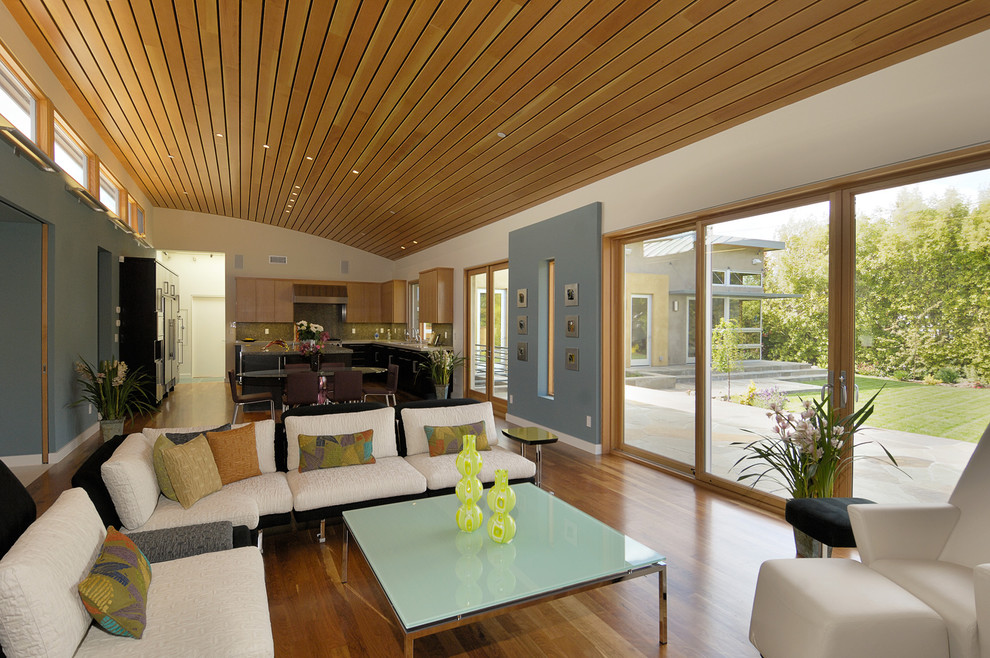 Immagine di un soggiorno minimal aperto e di medie dimensioni con pareti beige, pavimento marrone, soffitto in legno e parquet chiaro