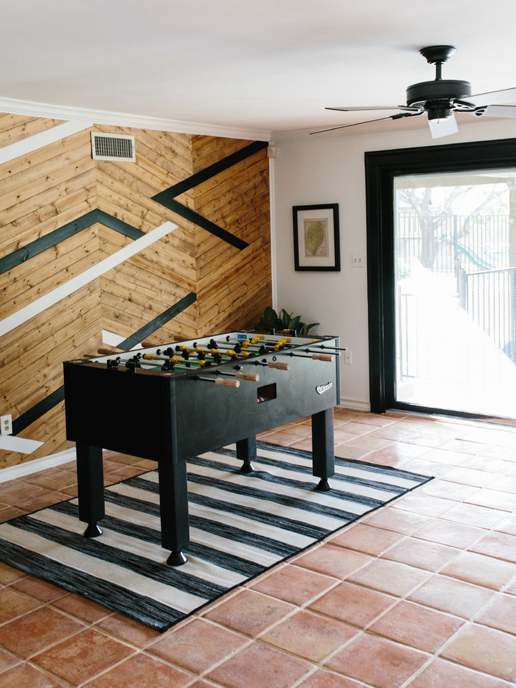 Example of a mid-sized eclectic enclosed terra-cotta tile and brown floor game room design in Austin with multicolored walls, no fireplace and a media wall