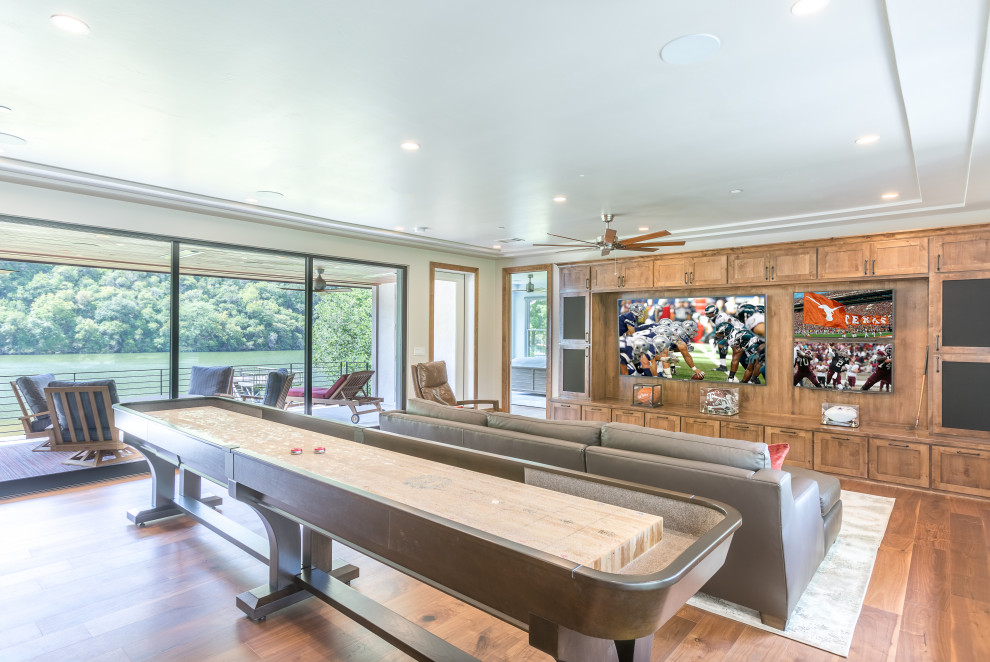 Design ideas for a medium sized traditional open plan games room in Austin with a game room, beige walls, medium hardwood flooring, no fireplace, a built-in media unit, brown floors and a drop ceiling.