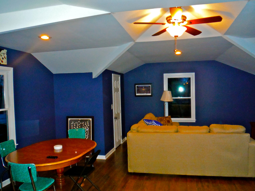 Aménagement d'une salle de séjour mansardée ou avec mezzanine contemporaine avec salle de jeu, un mur bleu et parquet foncé.