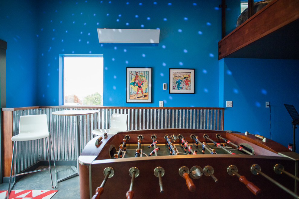 Cette photo montre une salle de séjour industrielle de taille moyenne et fermée avec salle de jeu, un mur bleu, sol en béton ciré, aucune cheminée, un téléviseur fixé au mur et un sol gris.